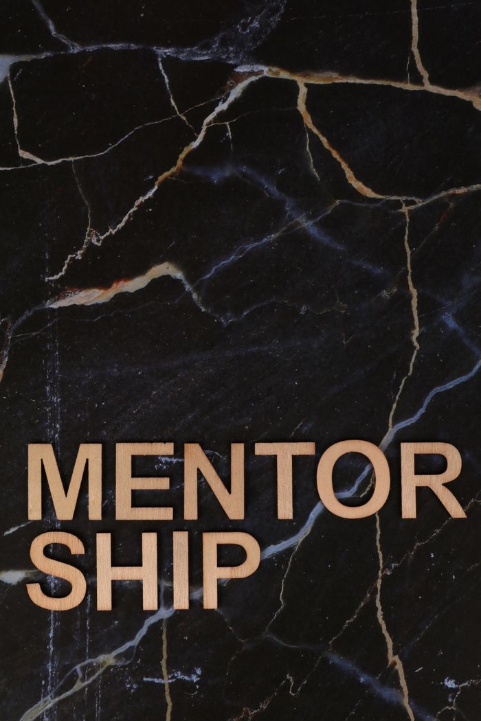 social-feed-img-01 Wooden letters spelling 'MENTORSHIP' on a dark marble background, inspiring guidance and support.